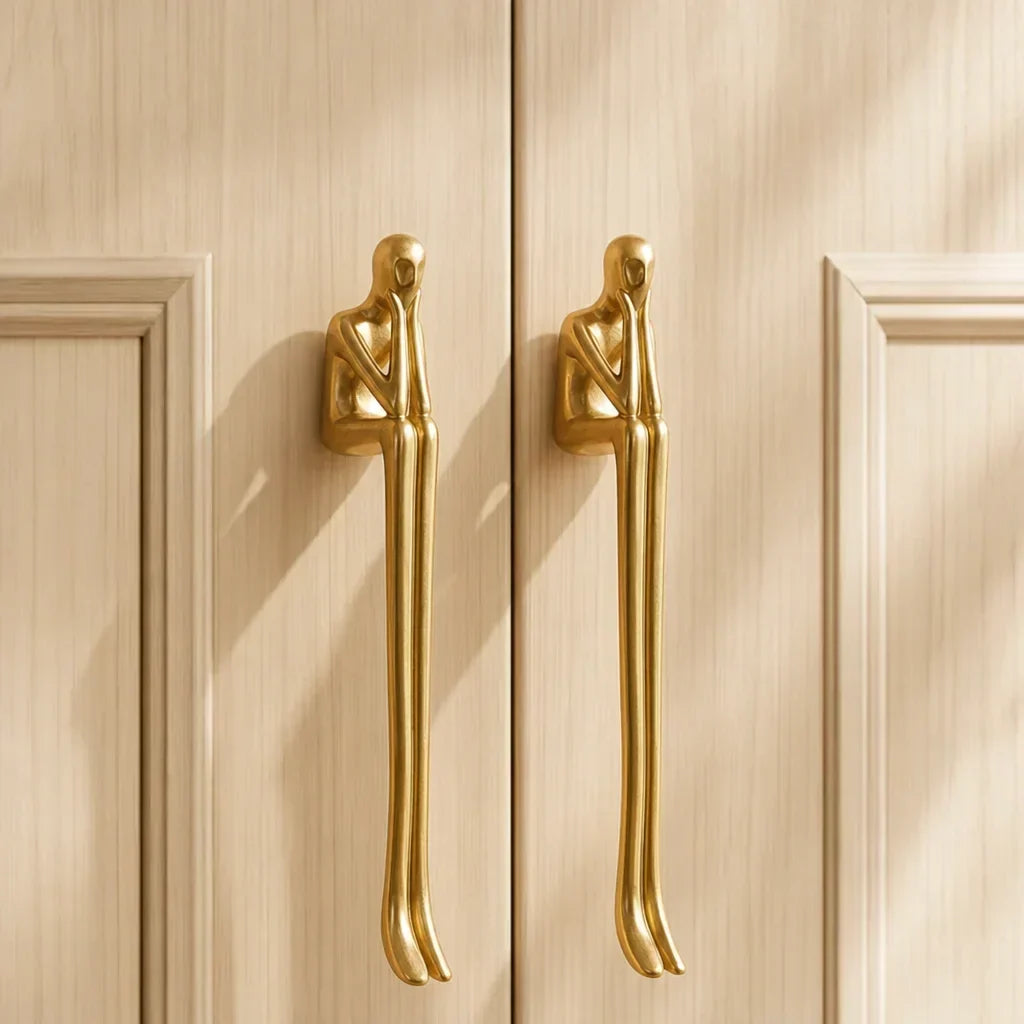 Brass sculpted cabinet handles on light wooden doors